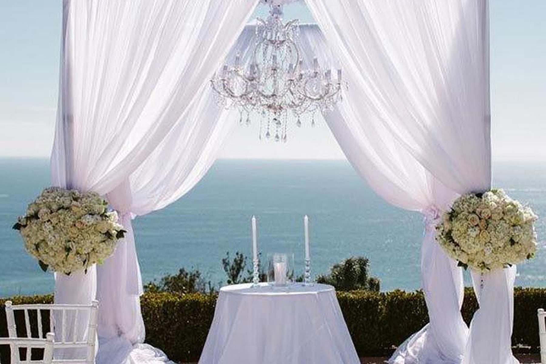 A floral ceremony arch overlooking the water