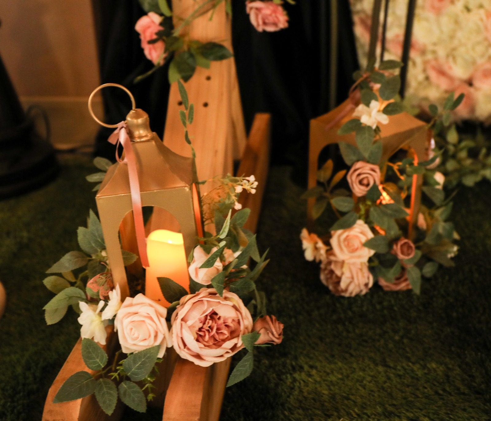 Wooden lanterns and blush roses lit by candlelight
