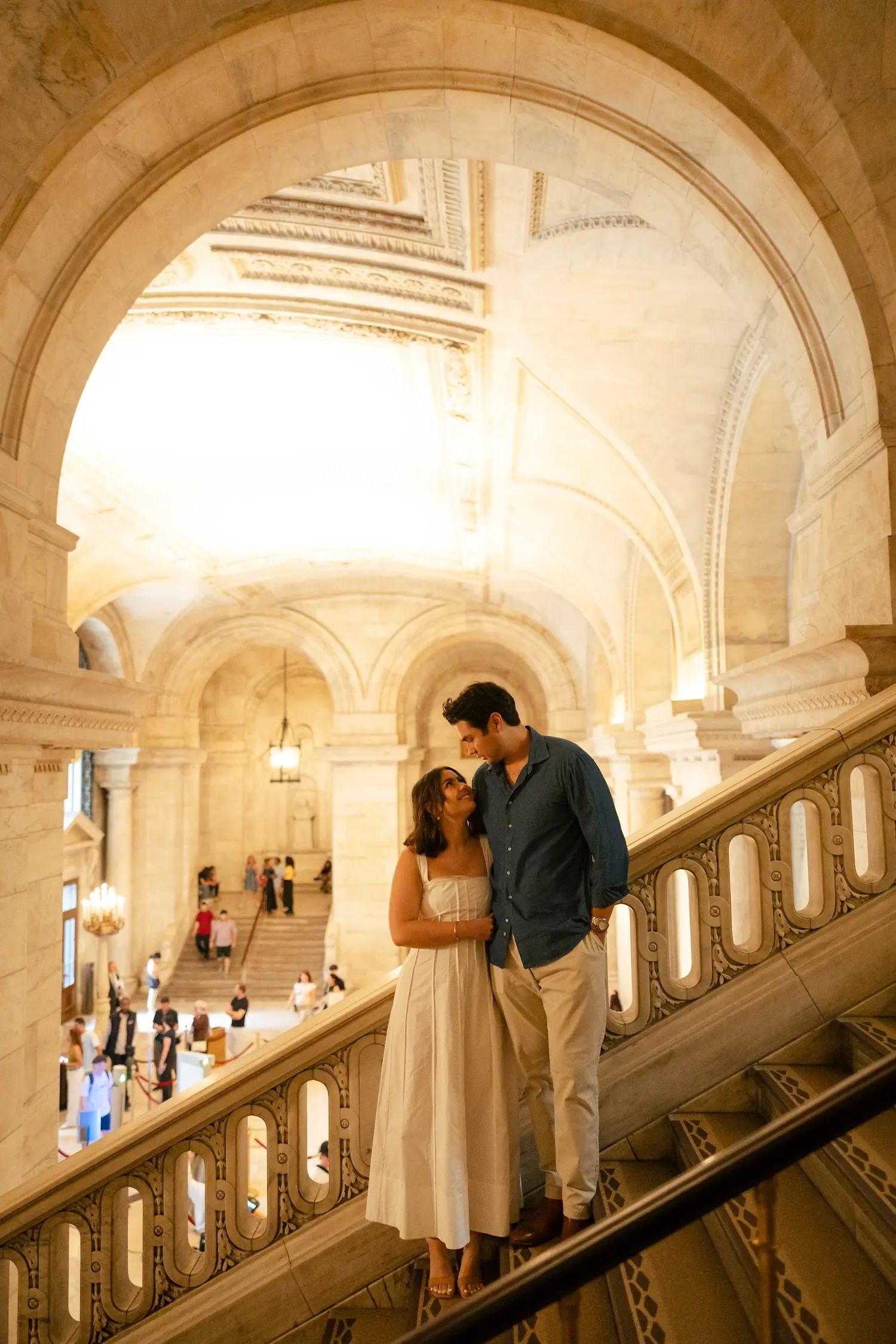The couple framed inside a sunlit stone archway