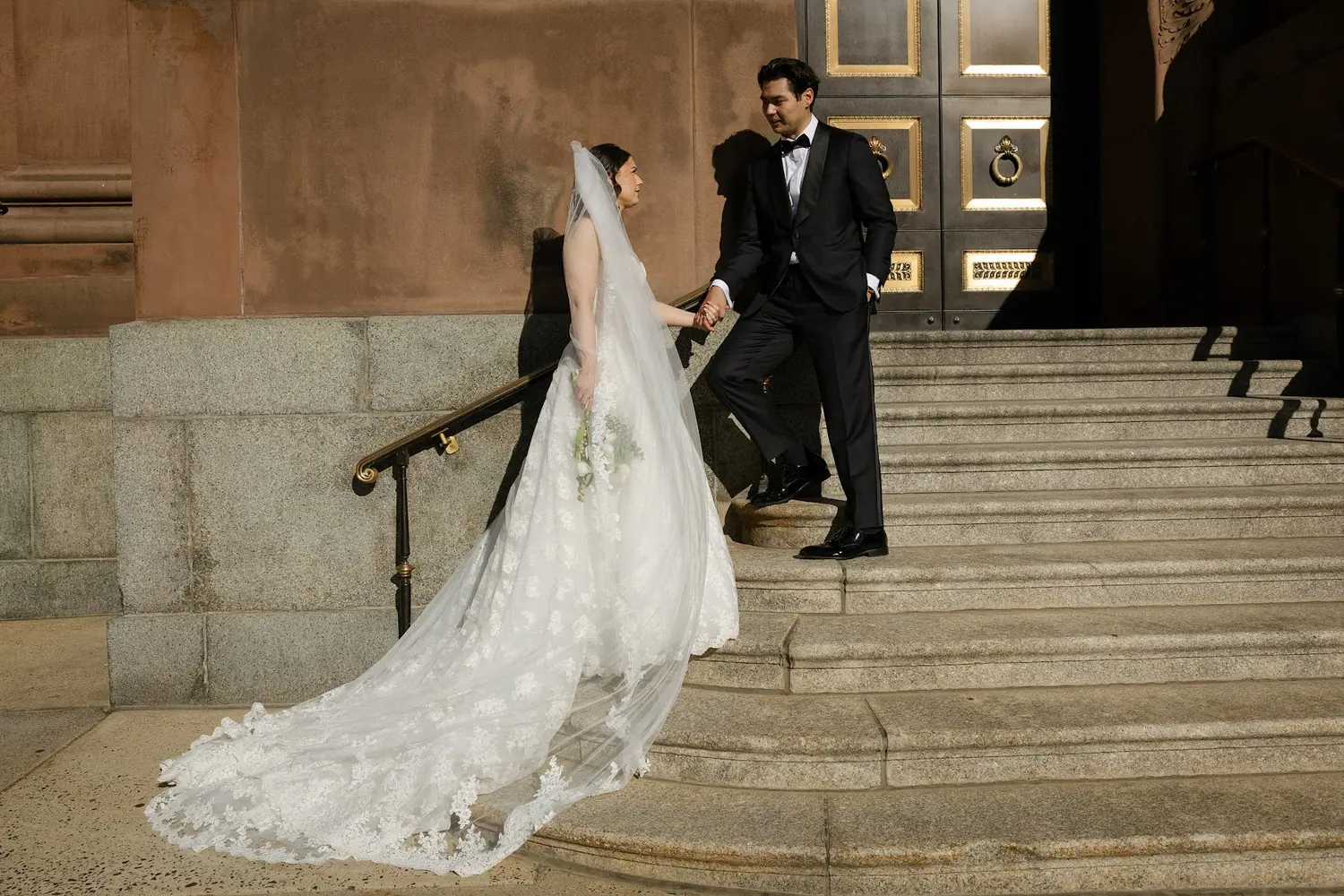 Veil spilling down the steps as the couple descends
