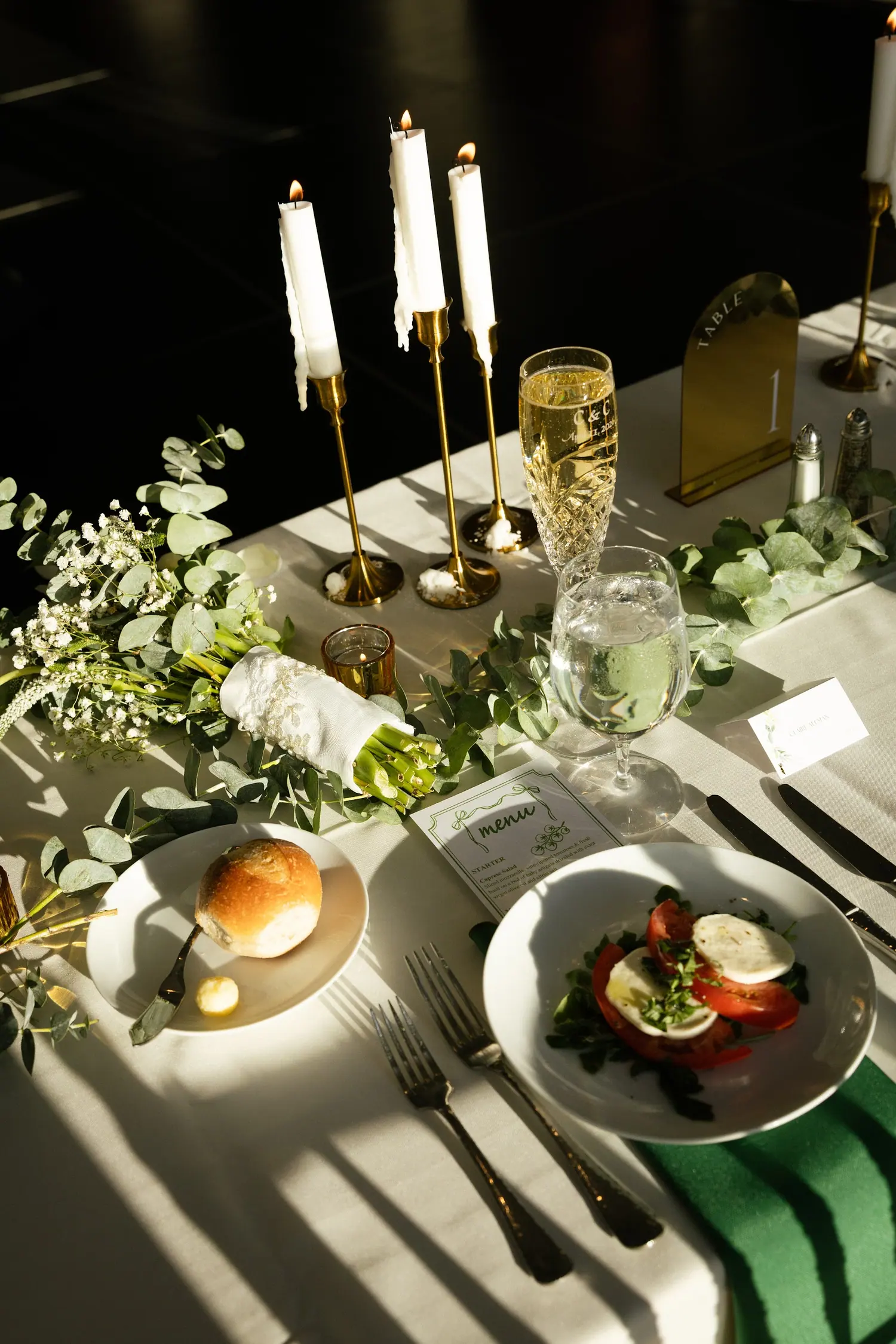 Candlelit place setting with greenery and gold