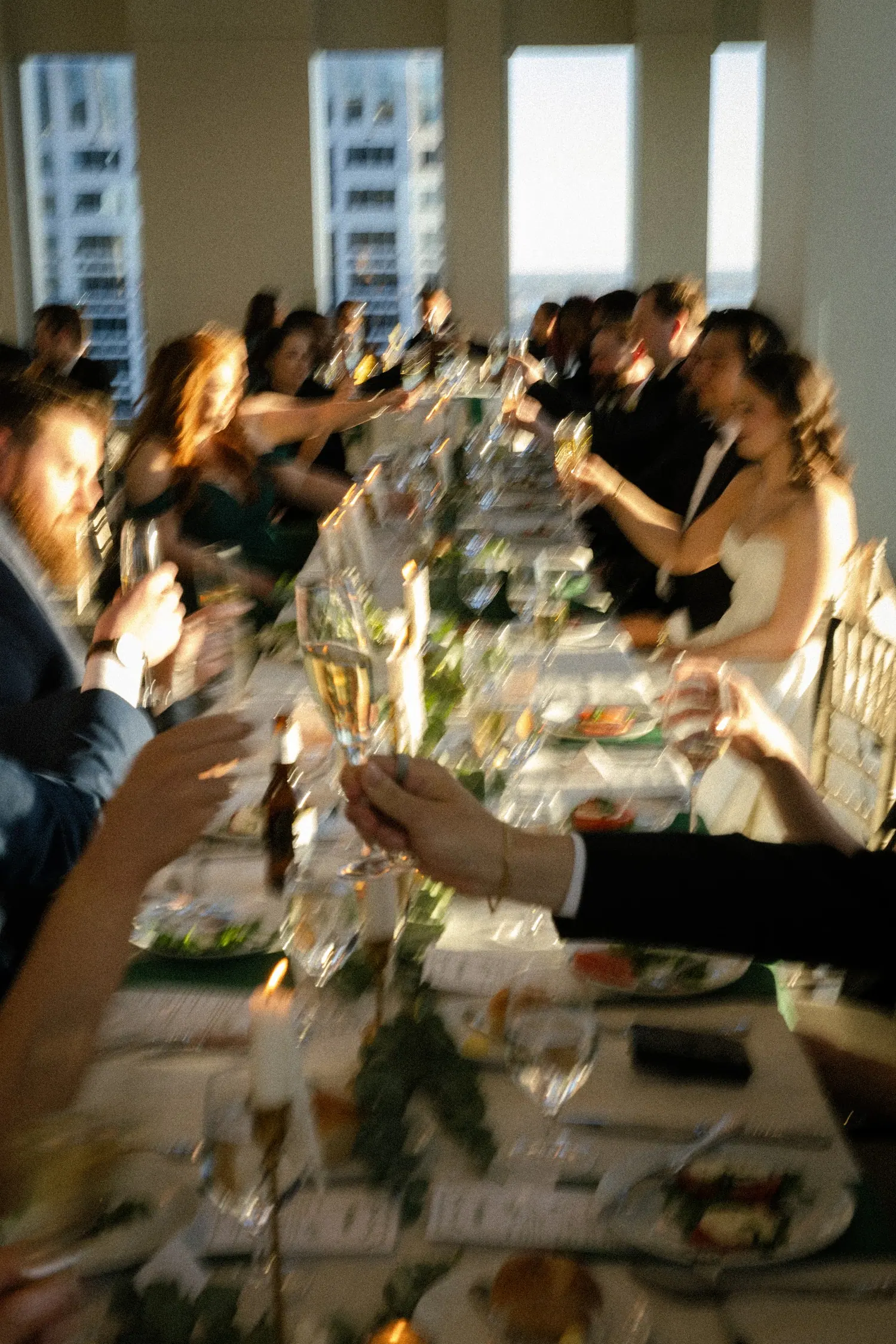 Guests raising glasses along a long dinner table